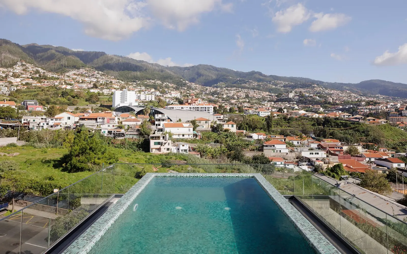 Piscina da cobertura com o Funchal e as montanhas em fundo